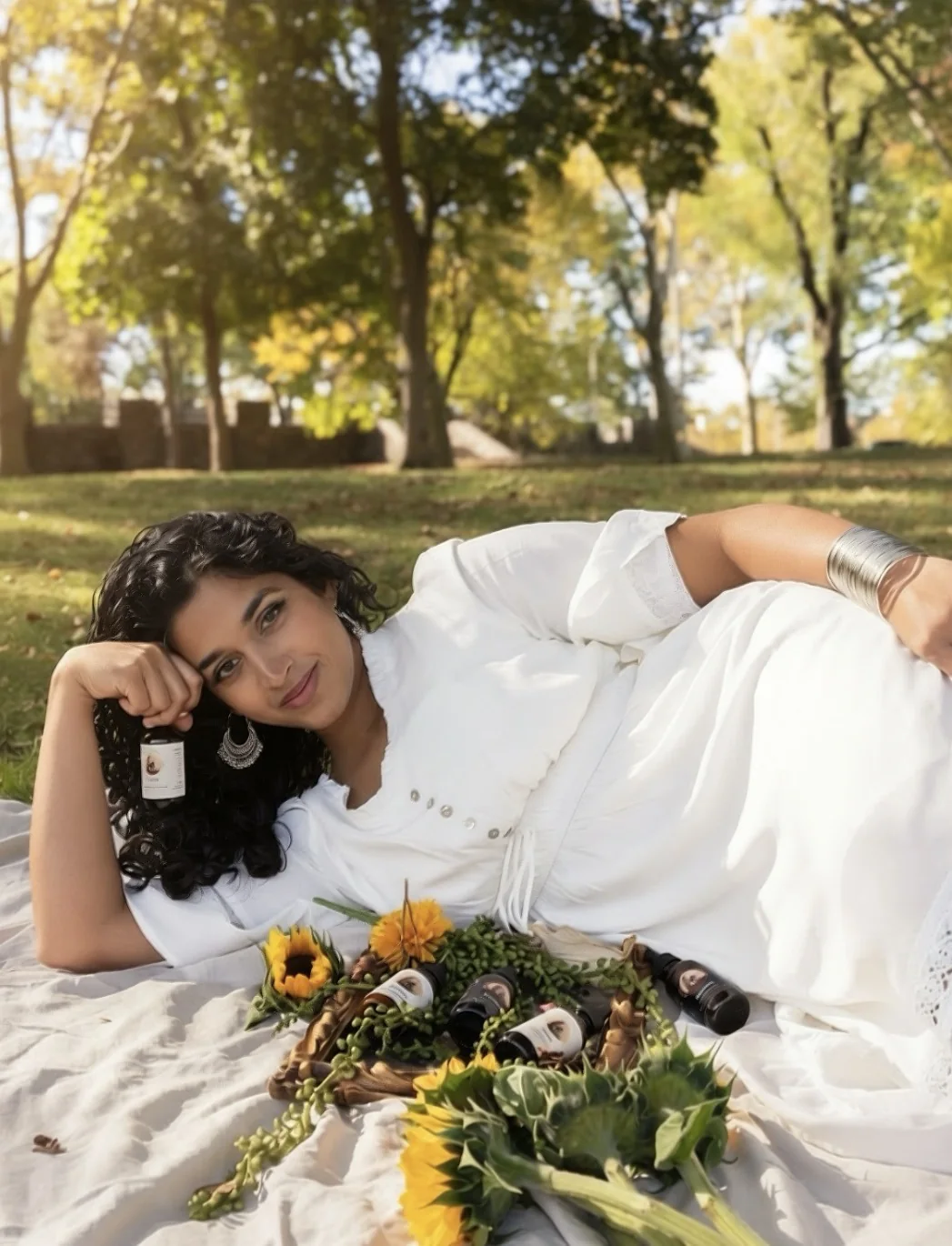 Founder of Ammi's Essence resting in a sunlit park with handmade hair oils